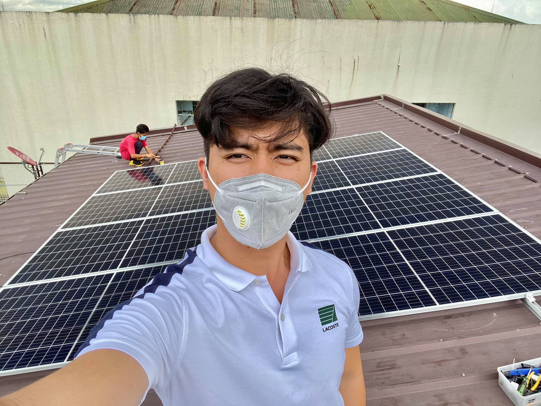 A Gleenergy installer on a rooftop beside a newly mounted solar panel array